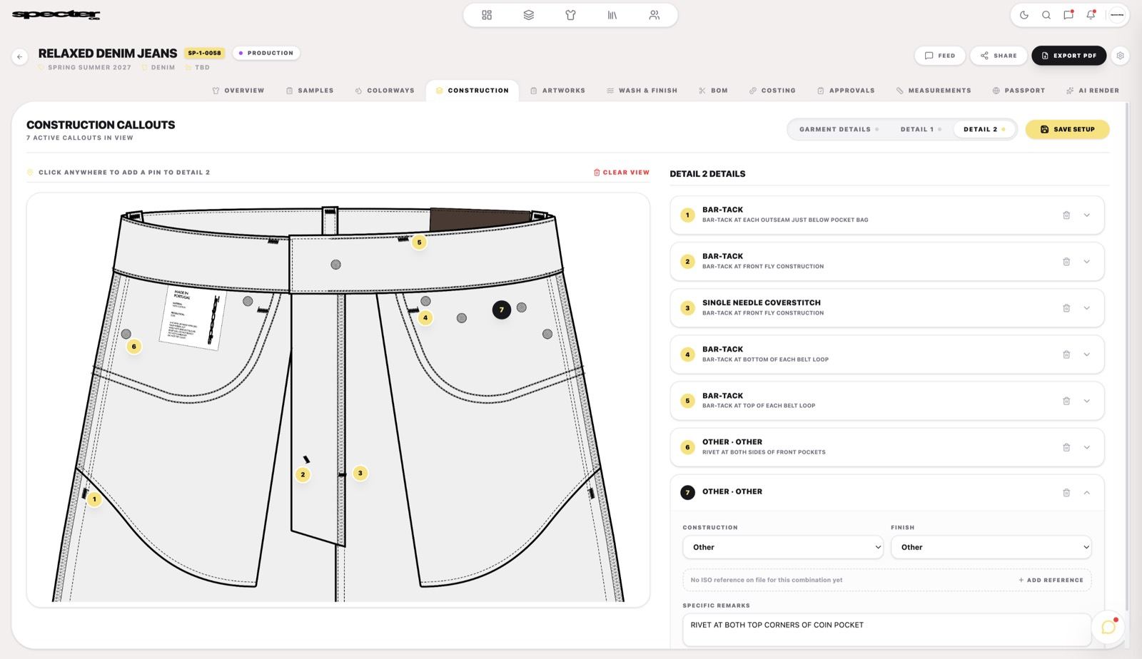 A tech pack open in Specter OS, with numbered construction callouts pinned to a denim jeans flat