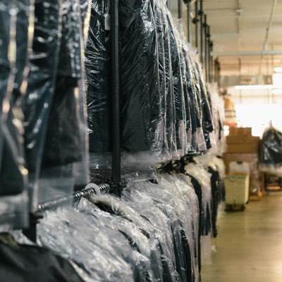 Long rails of bagged garments waiting to ship in a factory