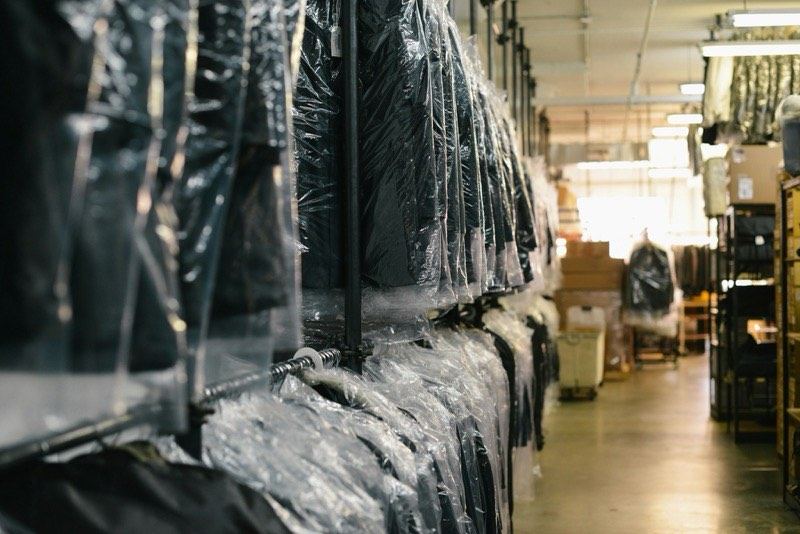 Long rails of bagged garments waiting to ship in a factory