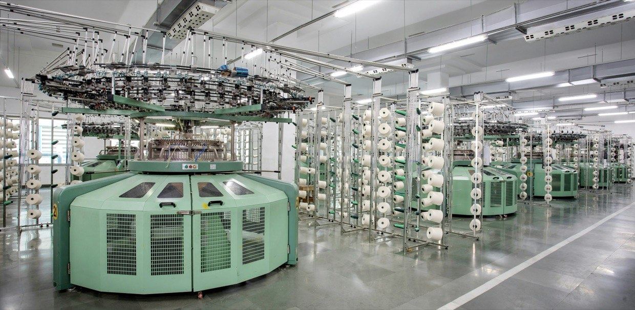 Circular knitting machines and cones of yarn on a textile mill floor