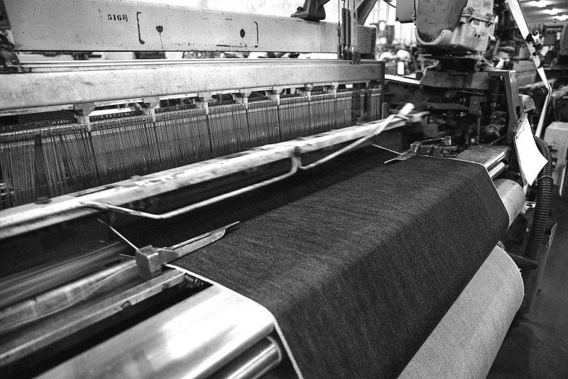 A bolt of denim loaded on a spreading machine in a cutting room