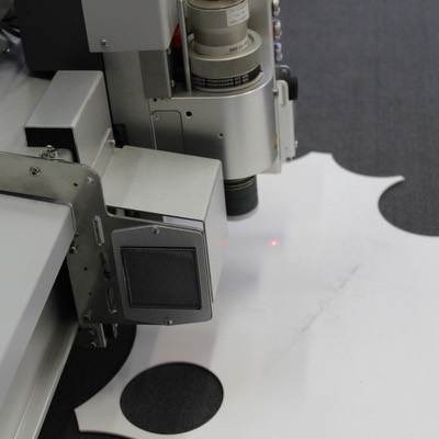 An automated cutter moving over laid fabric in a cutting room