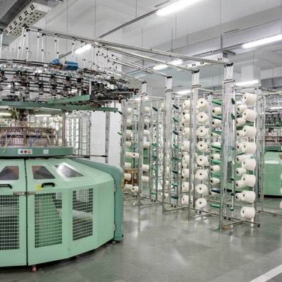 Circular knitting machines and cones of yarn on a textile mill floor