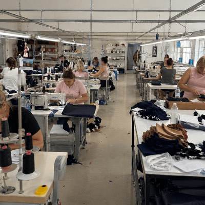 Machinists working at sewing stations on a garment factory floor