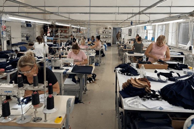 Machinists working at sewing stations on a garment factory floor