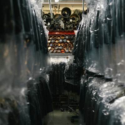 Finished garments hanging in protective plastic covers on a warehouse rail